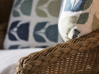 detailed shot of wicker chair completed by two beautiful cushions